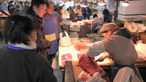 客と会話しながら、包丁を入れる(2016年12月31日、椿魚市場)
